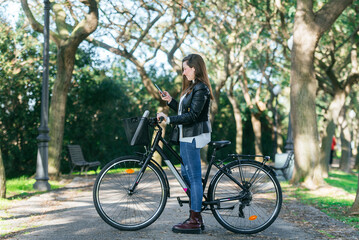 Woman on bike using mobile phone.