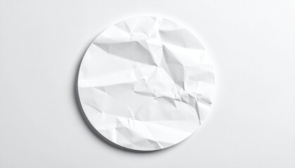 Overhead view of a crumpled white paper circle on a white surface