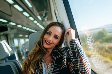 Smiling businesswoman relaxing on train during business trip © KikoStock