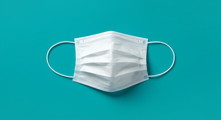White surgical mask against a turquoise background with copy space