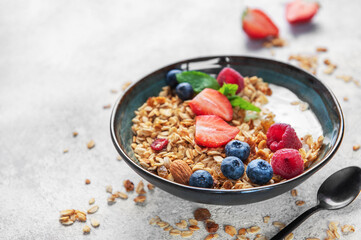 Granola bowl with yogurt, berries, and nuts for breakfast