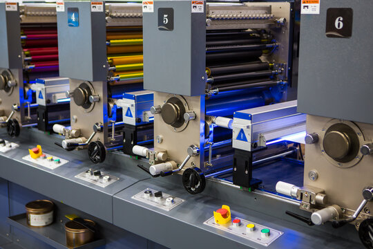 Detailed view of flexographic multi-color industrial printing press rollers. Modern packaging and printing technology.