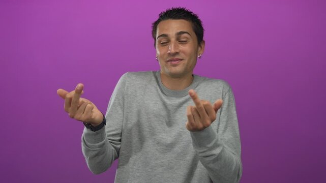 Young hispanic man flips middle finger at camera in purple studio; rebellion mischief defiance.