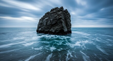 Solitary rock formation in ocean moody landscape with motion and texture