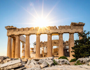 Fototapeta premium Ancient Greek temple ruins with sunburst against clear blue sky ancient ruins columns