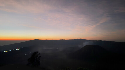 View of magnificent Mount Bromo, Mount Batok, and its giant caldera with sea of sand, with sunrise sky in the early morning. Located in Bromo Tengger Semeru National Park, East Java, Indonesia.