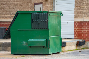 large green commercial dumpster for trash and recycling