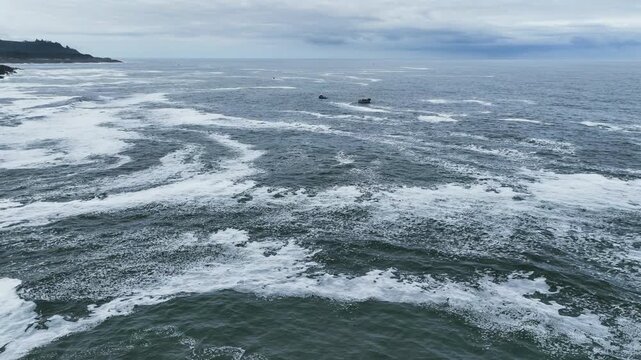 Aerial view rising toward whale watching boats on the coast of cloudy Oregon, USA