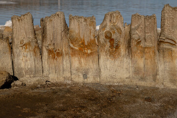 Weathered wooden posts with salt and rust stains