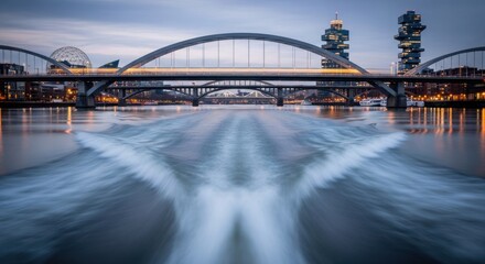 Cityscape view from water with bridges, buildings, lights, and wake