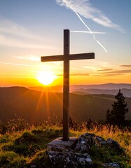 Wooden cross at sunrise over mountains