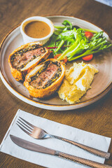 Beef Wellington Beef tenderloin topped with onion, mushroom, herbs, wrapped in turkey ham and wrapped in buttery puff pastry