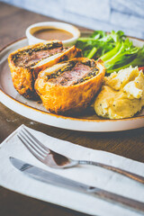 Beef Wellington Beef tenderloin topped with onion, mushroom, herbs, wrapped in turkey ham and wrapped in buttery puff pastry