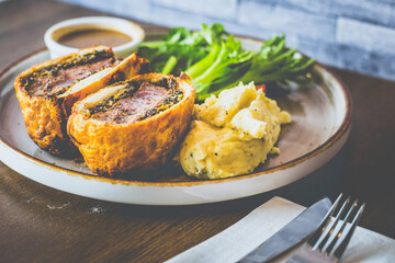 Beef Wellington Beef tenderloin topped with onion, mushroom, herbs, wrapped in turkey ham and wrapped in buttery puff pastry