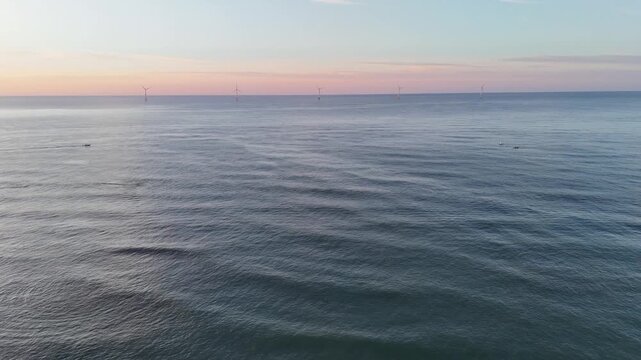 Aerial view of wind turbines standing tall in the ocean, a testament to renewable energy against the backdrop of the horizon, New Shoreham, Rhode Island, United States.