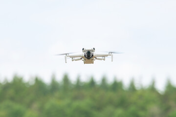 Flying drone in action, aerial copter, digital camera, modern technology used for photography, videography, surveillance and delivery service, agriculture, search and rescue