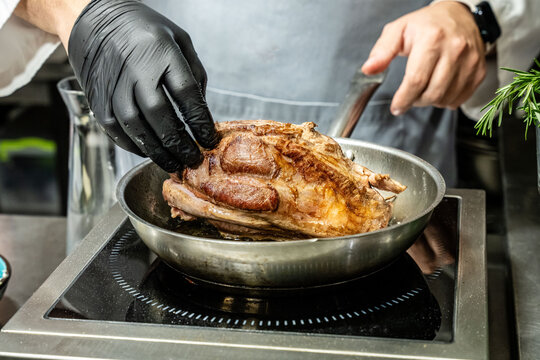Chef searing meat in pan