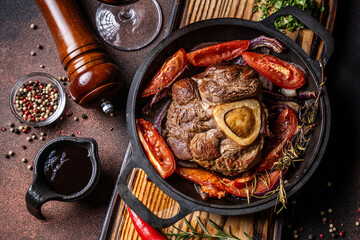 Braised beef shank with bone marrow and vegetables in cast iron pan