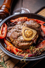 Closeup osso buco with bone marrow and roasted vegetables