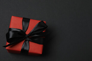 red gift boxes with black ribbons on a black background
