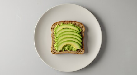 An overhead flat lay of a single slice of avocado toast on a ceramic plate, styled in a clean and simple minimalist manner with ample copy space.
