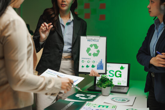 Businesswomen discussing recycling statistics during meeting