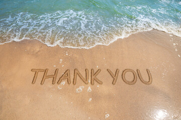 Thank you card design with words written on golden sand