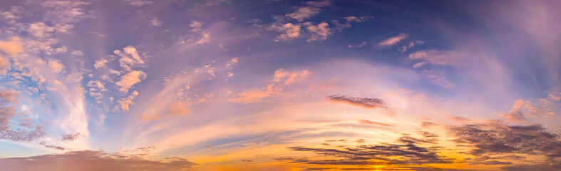 Real majestic sundown sky background with gentle colorful clouds evening sunset. Panoramic big size arched vaults of cirrus cloud in high-altitude wind flows and the dynamics of atmospheric fronts.
