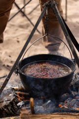Cooking at the campsite, adding a spice mixture to the cauldron