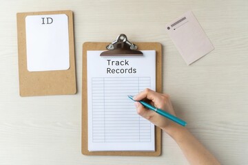 Person Writing on Medical Records Chart Held by Clipboard