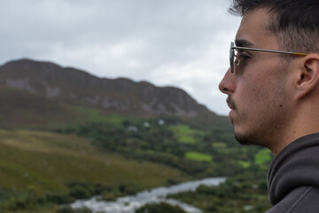 Perfil de un joven contemplando las vistas verdes 