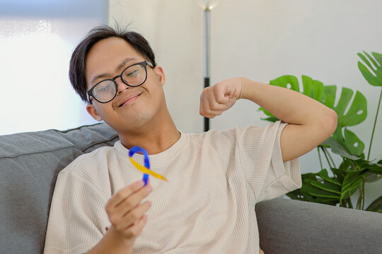 Young Boy Support Down Syndrome Awareness with Blue and Yellow Ribbon, Showing Strength and Hope - Powered by Adobe