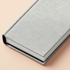 Gray textured book cover on peachy surface, angled view