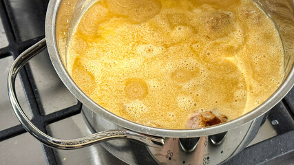 Golden broth simmers mysteriously, invoking hygge warmth, culinary alchemy, and autumnal equinox feasting, tantalizing rustic cooking traditions April 5, 2025, Barcelona, Spain