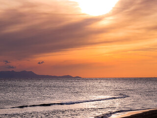  Sunset and seascapes , beautiful sunset seascape with dramatic clouds, calm waves, and rocky coastline. Scenic view of the ocean horizon and natural evening light.