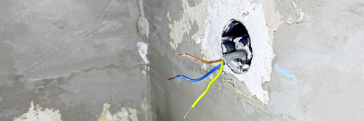 Frayed wires emerge from a timeworn wall, whispering the secrets of forgotten circuitry, akin to National Electric Safety Month, April 5 2025, Barcelona, Spain
