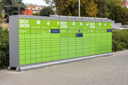 Outdoor parcel locker with bright green doors, a modern automated package delivery and collection point in an urban setting. Boxnow. Varna, Bulgaria. - 28.09.2025