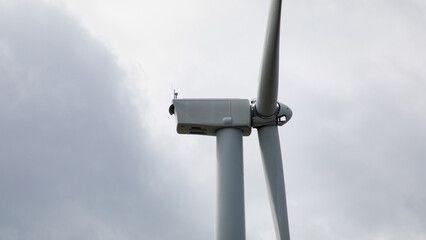 Towering wind turbine against brooding sky, harnessing gusty whispers, eco-futurism dance; World Wind Day, sustainable innovation April 5 2025, Barcelona, Spain