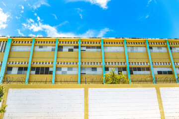 Pedernales, Dominican Republic, 8 august 2025. View of the facade of a typical Dominican school, paintend bright yellow against a blue sky.