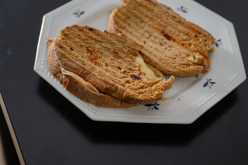 Sandwiches made of homemade bread toasted with ham, spreadable cheese and ketchup inside. Homemade food that is always good to start or end the day.