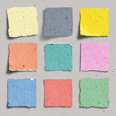 Fototapeta premium Nine colorful handmade square papers arranged on a textured surface. They show a variety of different colors. The torn edges on each paper gives a handmade feel