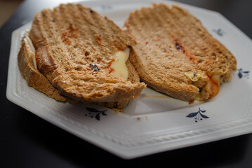 Sandwiches made of homemade bread toasted with ham, spreadable cheese and ketchup inside. Homemade food that is always good to start or end the day.