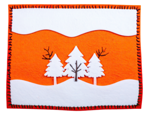 Handmade felt winter scene snow-covered trees against orange backdrop