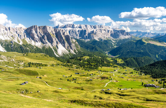 amazing view from Seceda on mountains Sella group and great meadows with huts in Dolomites in Italy