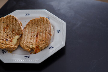 Sandwiches made of homemade bread toasted with ham, spreadable cheese and ketchup inside. Homemade food that is always good to start or end the day.