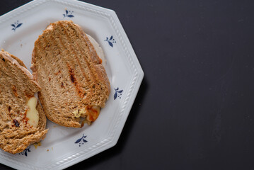 Sandwiches made of homemade bread toasted with ham, spreadable cheese and ketchup inside. Homemade food that is always good to start or end the day.