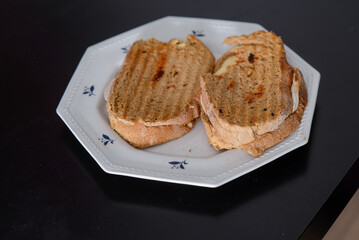Sandwiches made of homemade bread toasted with ham, spreadable cheese and ketchup inside. Homemade food that is always good to start or end the day.