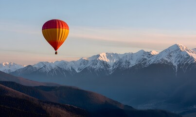 hot air balloon floating above snowy mountain range at sunrise