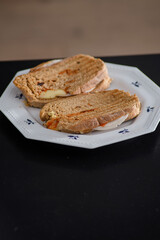 Sandwiches made of homemade bread toasted with ham, spreadable cheese and ketchup inside. Homemade food that is always good to start or end the day.