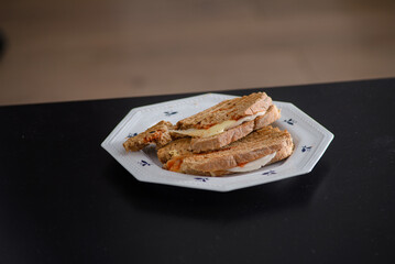 Sandwiches made of homemade bread toasted with ham, spreadable cheese and ketchup inside. Homemade food that is always good to start or end the day.